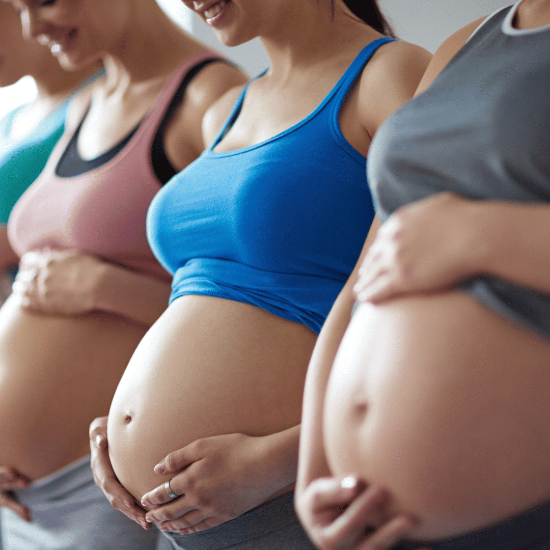 3 pregnant women in crop tops with baby bumps